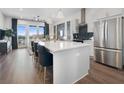 Open-concept kitchen with island seating, stainless steel appliances, and hardwood floors at 989 Bibbs Circle Nw # 25, Atlanta, GA 30318