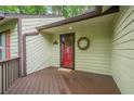 Inviting front porch features a red door, wooden deck, and charming wreath decor at 2174 Kinridge Rd, Marietta, GA 30062