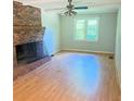 Bright living room with large brick fireplace, ceiling fan, and hardwood floors at 401 Mount Tabor Church Rd, Dallas, GA 30157