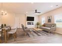 Bright living room features a large TV, a sleek ceiling fan, and an open floorplan that connects seamlessly with the dining area at 1673 Fuma Leaf Way, Mcdonough, GA 30253