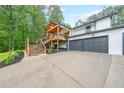Home exterior with a large driveway leading to an attached garage and a beautiful elevated deck at 110 W Putnam Ferry Rd, Woodstock, GA 30189