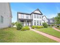 Attractive two-story house featuring a lush lawn and a quaint brick path at 3658 Madison St, College Park, GA 30337