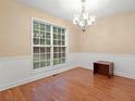Elegant dining room with hardwood floors, wainscoting, chandelier, and large window at 4544 Dorsett Shoals Run, Douglasville, GA 30135