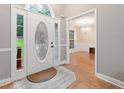 Bright entryway with decorative glass front door, sidelights, hardwood floors and chandelier view to dining room at 4544 Dorsett Shoals Run, Douglasville, GA 30135