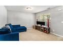 A cozy living room with a plush blue couch, beige carpet and large window for natural light at 752 Wood Bend Ct, Riverdale, GA 30296