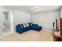 A cozy living room with a plush blue couch, beige carpet and large window for natural light at 752 Wood Bend Ct, Riverdale, GA 30296