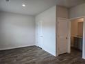 Spacious bedroom featuring hardwood floors, two closets, and an ensuite bath with granite countertop at 1669 Fuma Leaf Way, Mcdonough, GA 30253