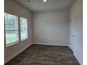 Bright living room features hardwood floors, large windows, and fresh, neutral paint at 1669 Fuma Leaf Way, Mcdonough, GA 30253