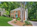 Beautiful two-story brick home with a vibrant lawn, mature trees, and a side-entry garage at 2696 Chancellor Way, Duluth, GA 30096