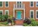 Close-up of the home's entrance featuring a bright blue door, white trim, and manicured landscaping at 2696 Chancellor Way, Duluth, GA 30096