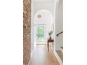 Bright hallway featuring a brick accent wall, white door and arched doorway for a modern yet rustic aesthetic at 2873 Bob White Sw Dr, Atlanta, GA 30311