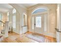 Bright foyer with hardwood floors, decorative rug, paneled walls, and a leaded glass door at 42 Greenland Trce, Atlanta, GA 30342