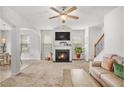 Comfortable living room with a fireplace, large windows, and a ceiling fan, creating a warm and inviting space at 5152 Rapahoe Trl, Atlanta, GA 30349