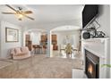 Expansive open-concept living room featuring a cozy fireplace, archways to the kitchen, and a ceiling fan for added comfort at 5152 Rapahoe Trl, Atlanta, GA 30349