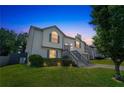 Inviting two-story home with manicured lawn, illuminated landscaping, gray stairs, and two-car garage at 7262 Sandpiper Way, Riverdale, GA 30274