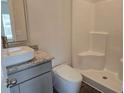Bathroom features a white tile shower and toilet with granite counters and a sink at 1661 Fuma Leaf Way, Mcdonough, GA 30253