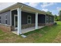 Exterior view of home's patio with white columns and gray brick, siding and trim at 1661 Fuma Leaf Way, Mcdonough, GA 30253
