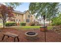 Landscaped backyard offering a fire pit, bench seating, and a wooded area with potential privacy at 4960 Haydens Walk Dr, Johns Creek, GA 30022
