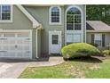 Inviting front entrance with well-maintained landscaping, a two-car garage, and manicured lawn at 850 Long Branch Cir, Sugar Hill, GA 30518