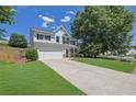 Lovely two-story home features a spacious driveway, lush lawn, and mature trees in a quiet neighborhood at 955 Mill Creek Ave, Canton, GA 30115