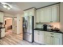 Kitchen with stainless steel refrigerator, white cabinets, granite counters, and modern flooring at 1580 Smyrna Sw Rd, Conyers, GA 30094