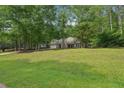 Well-kept home with mature trees and a large green front yard at 25 Pebble Creek Dr, Covington, GA 30016
