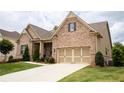 Lovely brick home featuring an attached two-car garage and a manicured lawn at 2665 Crowbrook Way, Cumming, GA 30040