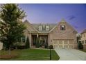 Beautiful brick home featuring manicured lawn, dormers, and an attached two car garage at 2665 Crowbrook Way, Cumming, GA 30040