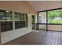Covered porch with stained wood flooring and neutral siding offers a cozy outdoor seating area at 85 Holly Dr, Carrollton, GA 30116