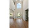 Grand foyer with high ceilings, a large window, and sleek hardwood flooring, creating an elegant entrance at 191 Kyndal Dr, Hampton, GA 30228