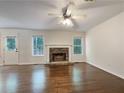 Bright living room with a stone fireplace, ceiling fan and two large windows at 6001 Deer Springs Nw Ln, Acworth, GA 30101