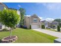 Attractive two-story home featuring manicured lawn, concrete driveway, and established landscaping at 104 Auburn Crossing Way, Auburn, GA 30011