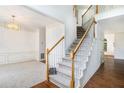 Bright foyer featuring wood floors, a staircase with white railings, and elegant trim work at 200 Ridge Bluff Ln, Suwanee, GA 30024