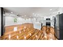 Expansive open-concept living space featuring hardwood floors, a sleek fireplace and a modern kitchen with stainless appliances at 2798 Hutchins Rd, Lawrenceville, GA 30044