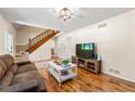 Bright living room with hardwood floors, a staircase, and a comfortable sofa with plenty of seating at 4150 Kalb Sw Ct, Smyrna, GA 30082