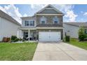 Attractive two-story home featuring a well-kept lawn, brick accents, a two-car garage, and a cozy front porch at 5322 Burrus Sw Ln, Mableton, GA 30126