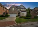 Charming brick two-story home featuring a well-manicured lawn, attached garage and manicured bushes at 2321 Norbury Se Cv, Smyrna, GA 30080