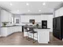 Modern white kitchen features an island, black countertops, and stainless steel appliances at 2321 Norbury Se Cv, Smyrna, GA 30080