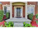 Charming brick home entrance with a covered porch, columns, and lush landscaping at 475 Bayswater Way, Suwanee, GA 30024
