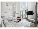 Bright living room boasting soaring ceilings, large windows, and a cozy seating area at 4975 Skyland Pkwy, Cumming, GA 30028
