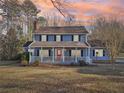 Inviting two-story home with a cozy front porch, perfect for enjoying the outdoors at sunset at 130 Thornton Dr, Fayetteville, GA 30214