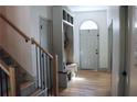 Bright foyer with wood floors, coat rack with bench, and staircase enhances the home's welcoming atmosphere at 2193 Kildare Nw Way, Kennesaw, GA 30152