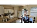 Functional kitchen with white cabinets, essential appliances, and an adjacent dining area offering a seamless flow at 3263 Mill Springs Circle Northeast Cir, Buford, GA 30519