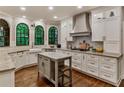 Elegant kitchen featuring stainless steel appliances, custom white cabinets, and beautiful hardwood floors at 3275 Lord N Lady Ln, Alpharetta, GA 30022