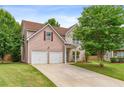 Charming two-story home featuring a two-car garage, well-maintained lawn, and lush trees at 4515 Ambassador Way, Cumming, GA 30040