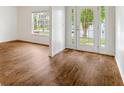 Bright living room with hardwood floors, large window, and entry to second room at 4515 Ambassador Way, Cumming, GA 30040