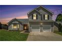 Two-story home with lovely landscaping, bay window, and attached two car garage at dusk at 4578 Score Ct, Snellville, GA 30039