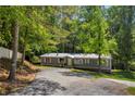 View of a home on a tree-lined lot with long driveway, showcasing its idyllic setting at 6235 Akins Way, Cumming, GA 30041