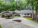Charming brick home with lush landscaping, a circular driveway and a covered front porch at 630 Buttercup Trce, Johns Creek, GA 30022