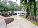 Charming brick home with lush landscaping, a circular driveway and a covered front porch at 630 Buttercup Trce, Johns Creek, GA 30022